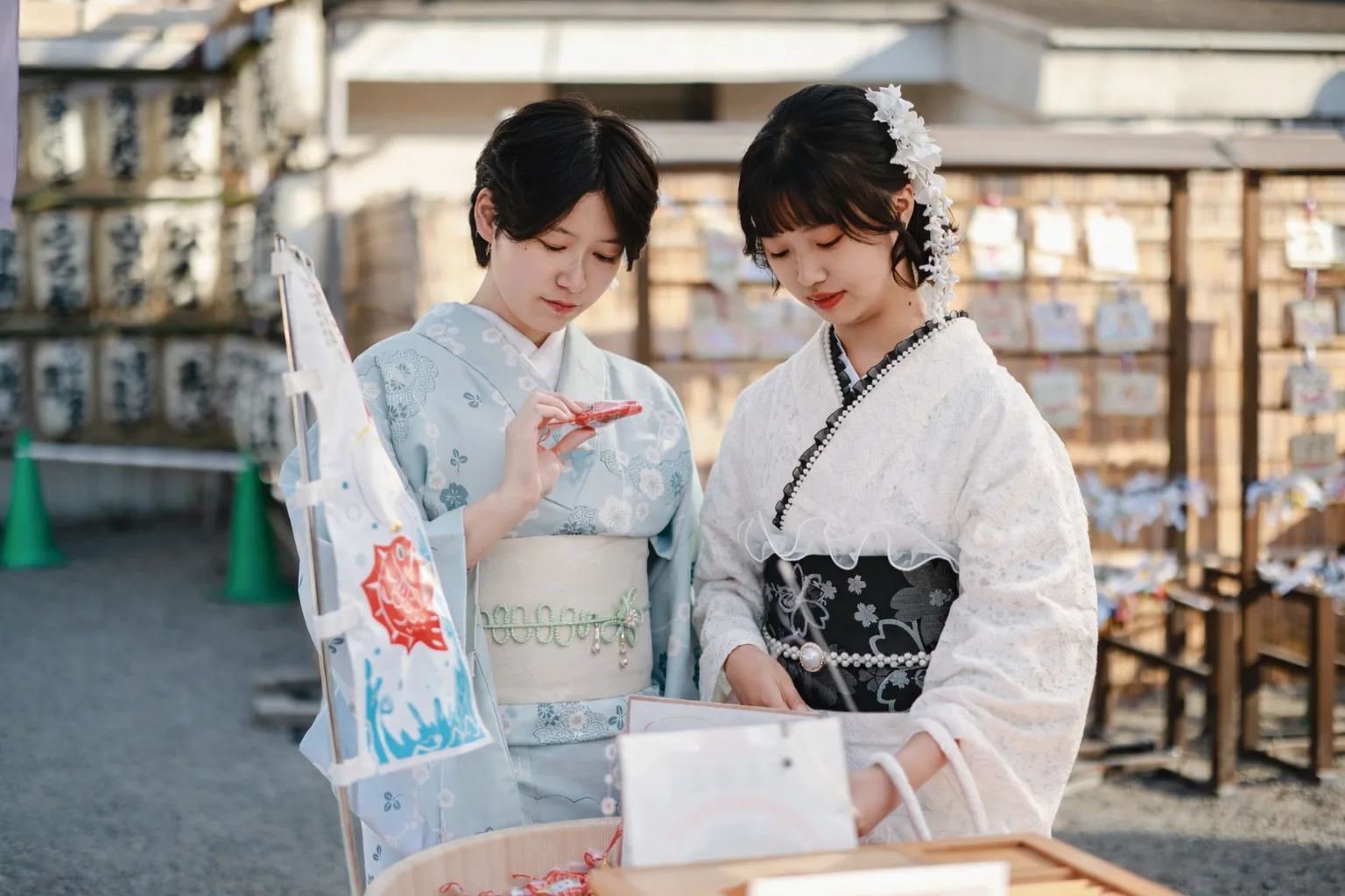 Two guests in kimono reading omikuji fortunes at Senso-ji Temple
